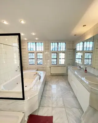 a large bathroom with a tub and two sinks at Le FauBourg Suites in Antwerp