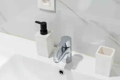 a white bathroom with a sink with a faucet at luxueux appartement 5 chambre in Brussels