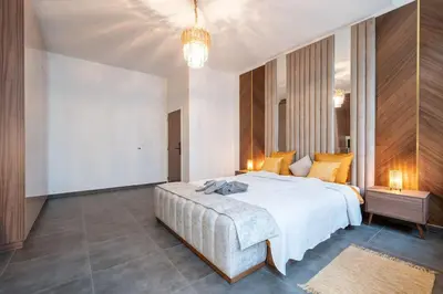 a bedroom with a large white bed and a chandelier at luxueux appartement 5 chambre in Brussels