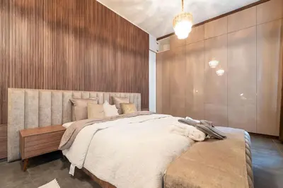a bedroom with a large bed and a wooden wall at luxueux appartement 5 chambre in Brussels