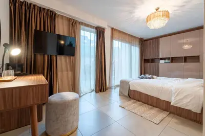 a bedroom with a bed and a desk and a television at luxueux appartement 5 chambre in Brussels