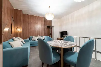 a living room with a blue couch and a table and chairs at luxueux appartement 5 chambre in Brussels