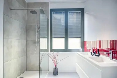 a bathroom with two sinks and a glass shower at Wonderful 6P duplex in Antwerp in Antwerp