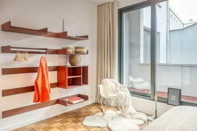 a room with a bed and a chair and a window at Smart and cosy 4P Apt in Antwerp with balcony in Antwerp