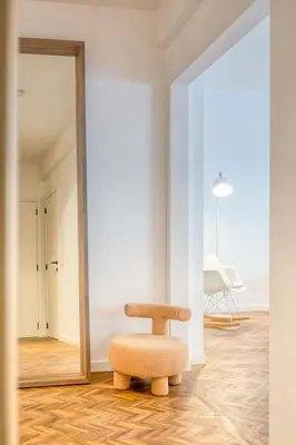 a chair sitting in a room with a mirror at Ample 2-BR Apt in Antwerp in Antwerp