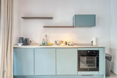 a kitchen with blue cabinets and a stove at Ample 2-BR Apt in Antwerp in Antwerp