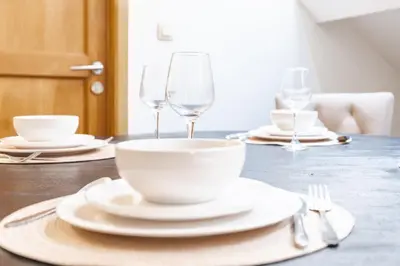 a table with white plates and wine glasses on it at Le Havre de Lumière à Etterbeek in Brussels