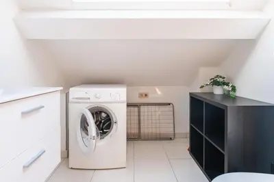a white laundry room with a washer and dryer at Le Havre de Lumière à Etterbeek in Brussels