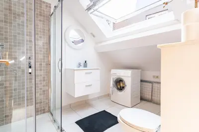 a bathroom with a toilet and a glass shower stall at Le Havre de Lumière à Etterbeek in Brussels