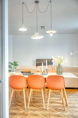 a dining room table with four orange chairs in a kitchen at 2-BR Haven in Antwerp in Antwerp