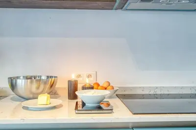 a counter with a bowl of oranges and a bowl of cheese at 2-BR Haven in Antwerp in Antwerp
