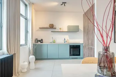 a kitchen with blue cabinets and a table at Unique 2-BR Antwerp Apt in Antwerp