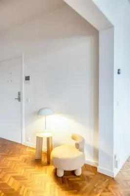 a white room with a chair and a lamp at Unique 2-BR Antwerp Apt in Antwerp
