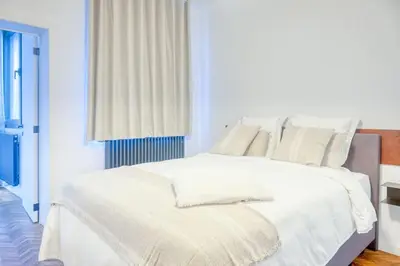 a white bed with white sheets and pillows at Unique 2-BR Antwerp Apt in Antwerp