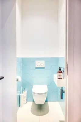 a blue bathroom with a toilet and a sink at Unique 2-BR Antwerp Apt in Antwerp