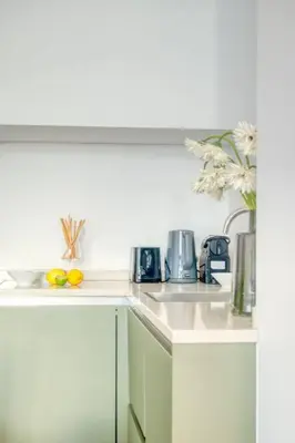 a kitchen with two sinks and a coffee maker at Cozy Retreat in Antwerp with balcony in Antwerp