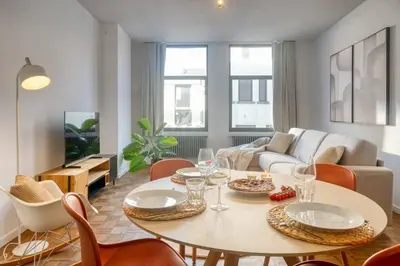a living room with a table and chairs at Cozy Retreat in Antwerp with balcony in Antwerp