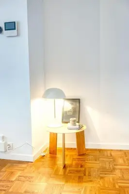 a table with a coffee cup and a lamp in a room at Cozy Retreat in Antwerp with balcony in Antwerp