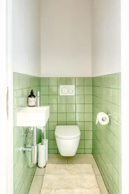 a green tiled bathroom with a toilet and a sink at Cozy Retreat in Antwerp with balcony in Antwerp