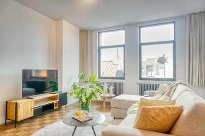 a living room with a couch and a tv at Magical renovated home in Antwerp in Antwerp