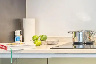 a counter with apples and a book on a counter top at Magical renovated home in Antwerp in Antwerp