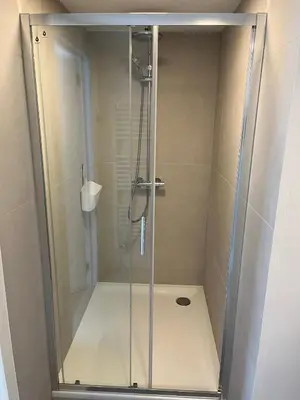 a shower with a glass door in a bathroom at Business Accommodation 'Eclectic Living' Nomad in Geel