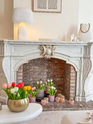 a living room with a fireplace with flowers on a table at Mansion RL with Unique Decoration in Antwerp