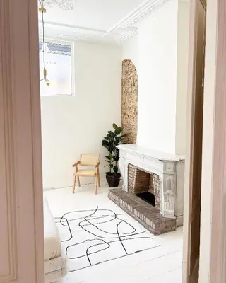 a white living room with a fireplace and a chair at Mansion RL with Unique Decoration in Antwerp