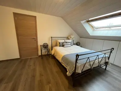 a bedroom with a bed and a skylight at B&B Het KoeKoeKsnest Schelle in Schelle