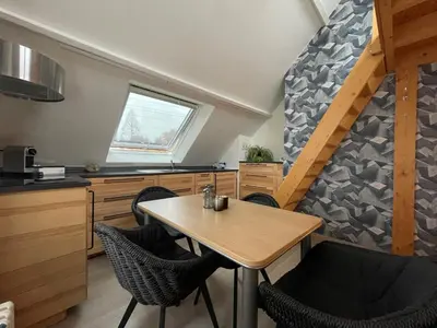 a kitchen with a table and chairs in a room at B&B Het KoeKoeKsnest Schelle in Schelle