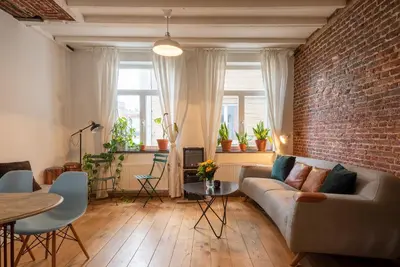 a living room with a couch and a brick wall at St Catherine Duplex Residence in Brussels