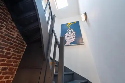 a stairway with a picture of a hand holding a candle at St Catherine Duplex Residence in Brussels
