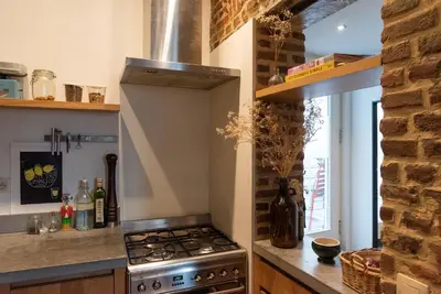 a kitchen with a stove top oven next to a counter at St Catherine Duplex Residence in Brussels