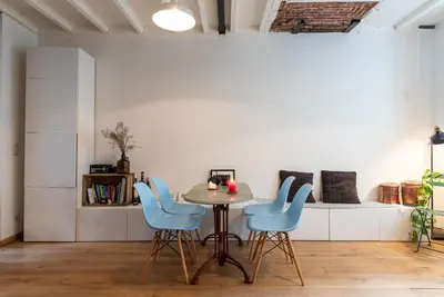 a dining room with a table and blue chairs at St Catherine Duplex Residence in Brussels