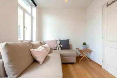 a couch in a living room with a teddy bear on it at St Catherine Duplex Residence in Brussels