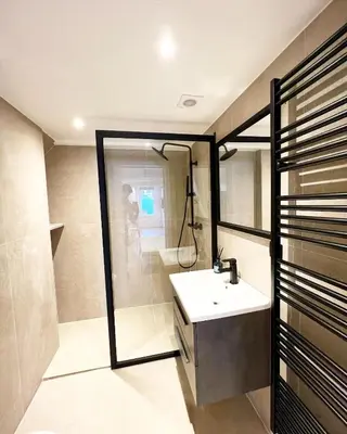 a bathroom with a sink and a shower at Mayfair Suites in Antwerp