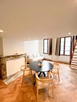 a living room with a table and chairs and a couch at Mayfair Suites in Antwerp