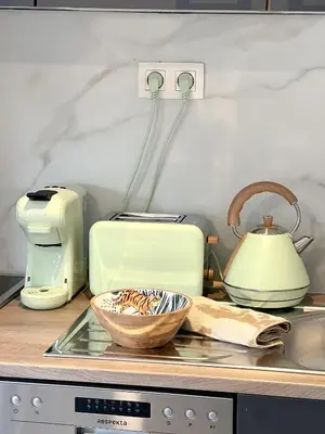 a kitchen counter with a toaster and a bowl of food at Mayfair Suites in Antwerp