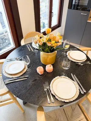 a black table with plates and a vase of flowers at Mayfair Suites in Antwerp