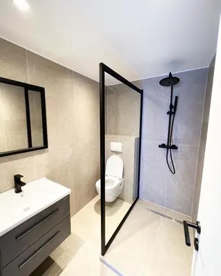 a bathroom with a shower with a toilet and a sink at Mayfair Suites in Antwerp
