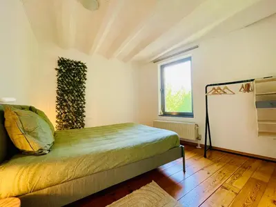 a bedroom with a bed in a room with a window at Oasis-Spacious Loft in Excellent Location in Brussels