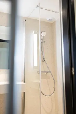 a shower with a glass door in a bathroom at Citybox Brussels Centre Louise in Brussels