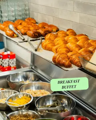 a buffet filled with lots of croissants and other food at Citybox Brussels Centre Louise in Brussels