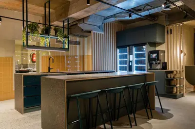 a kitchen with blue cabinets and a bar with stools at Citybox Brussels Centre Louise in Brussels