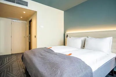 a bedroom with a large bed with white sheets at Citybox Brussels Centre Louise in Brussels
