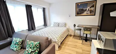 a small room with a bed and a desk at Apartment Chez Esmara et Philippe in Brussels