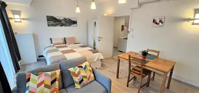 a bedroom with a bed and a table and a dining room at Apartment Chez Esmara et Philippe in Brussels