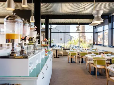 a restaurant with tables and chairs and windows at Budget Rooms by Ghent River in Ghent