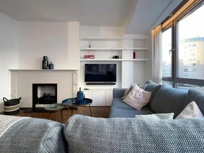 a living room with a couch and a fireplace at Cosy apartment for 2p-4p Ghent in Ghent