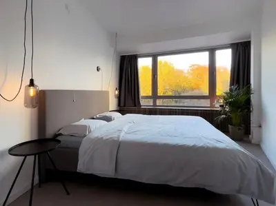 a bedroom with a large bed and a window at Cosy apartment for 2p-4p Ghent in Ghent